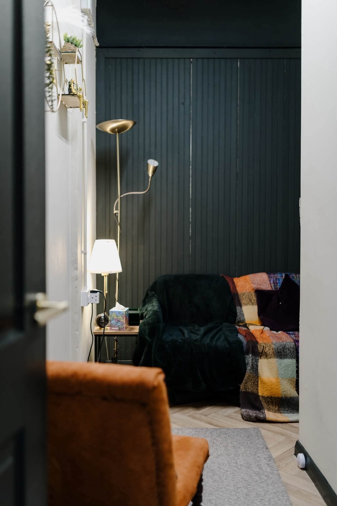 Blue velvet chair with plants and side table in therapy room
